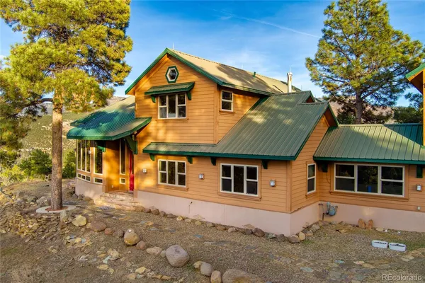 a front view of a house with a tree