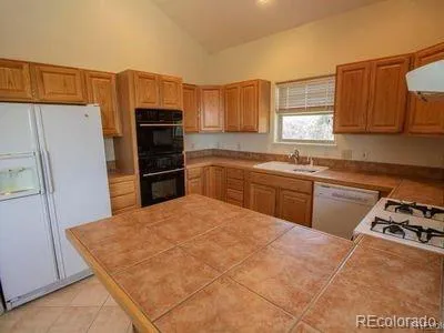 a kitchen with a stove a refrigerator and a sink