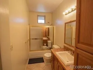 a bathroom with a granite countertop sink toilet a mirror and shower