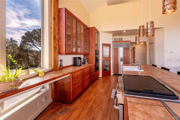 a view of a kitchen with a large window and cars parked in front of it