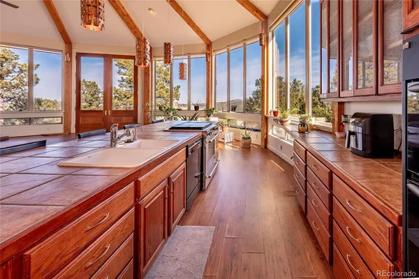 a large kitchen with stainless steel appliances a lot of counter space and a wooden floors