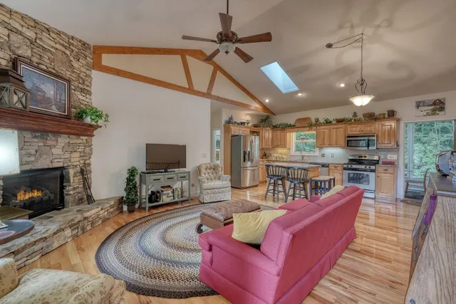 a kitchen with stainless steel appliances granite countertop a sink dishwasher and microwave with wooden floor