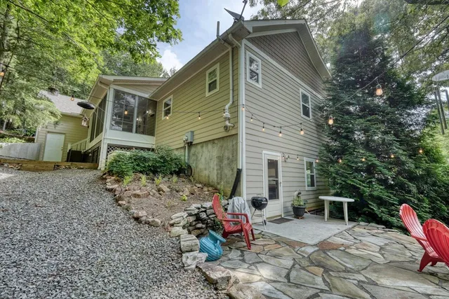 a view of a lush green forest with a house