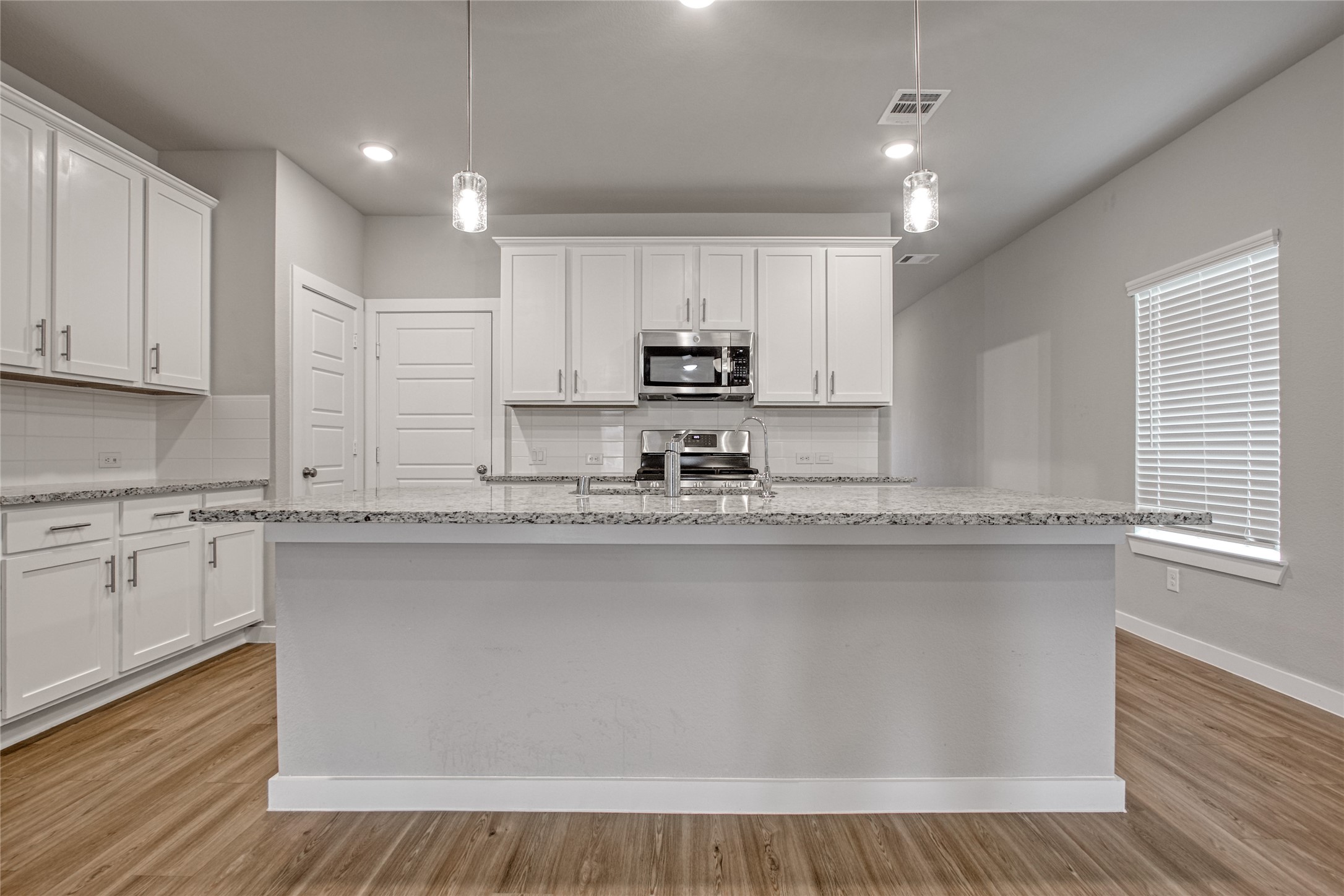 3327 Trl Vw Drive Rosenberg, TX 77471 - Photo 7 of 30 a kitchen with stainless steel appliances granite countertop a stove a sink and white cabinets