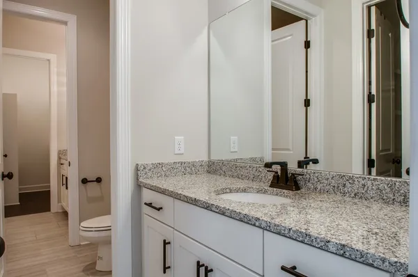a bathroom with a granite countertop sink and a mirror