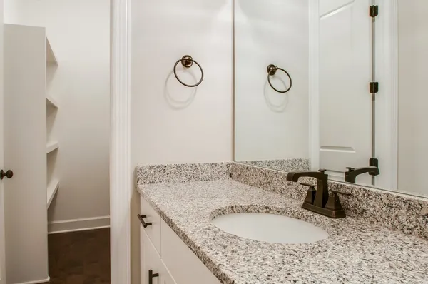 a bathroom with a granite countertop sink and a mirror
