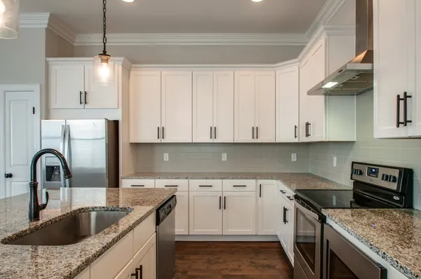 a kitchen with granite countertop a sink stainless steel appliances and cabinets