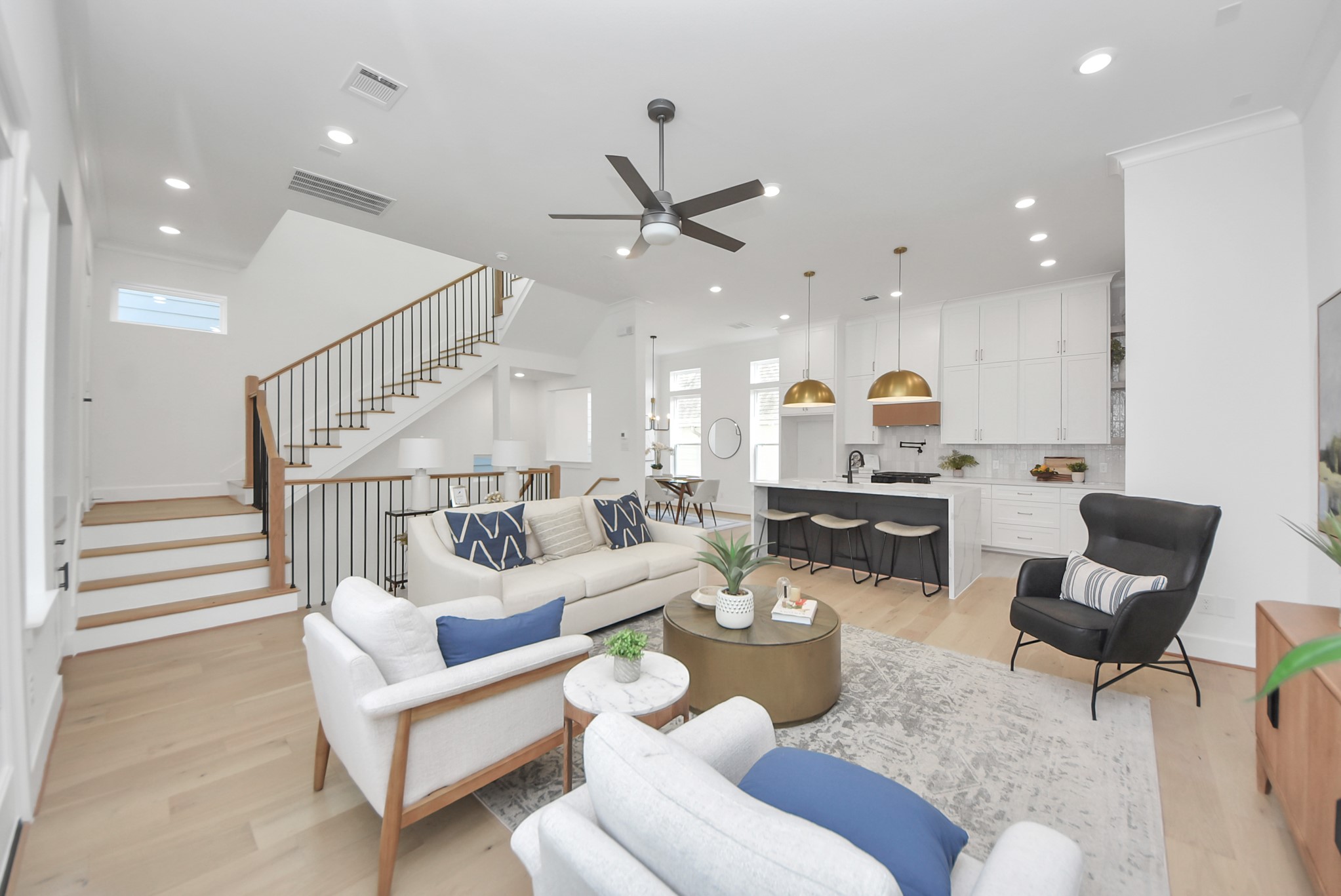 925 Fisher Street, Unit D Houston, TX 77018 - Photo 47 of 47 Step into this spacious, modern living area, where an open floor plan effortlessly combines a sleek kitchen and cozy seating. Natural light fills the room, highlighting the elegant staircase and neutral finishes. This inviting space is perfect for entertaining guests or enjoying quiet moments of relaxation.