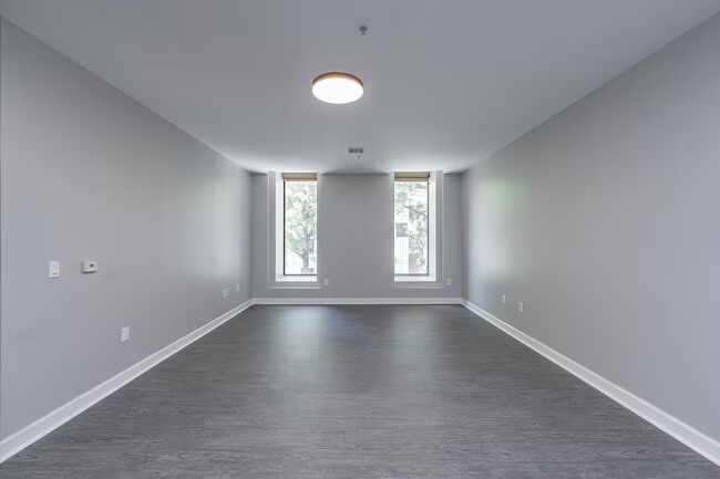 333 State Street, Unit 106 Bridgeport, CT 06604 - Photo 6 of 8 a view of an empty room with a window and wooden floor