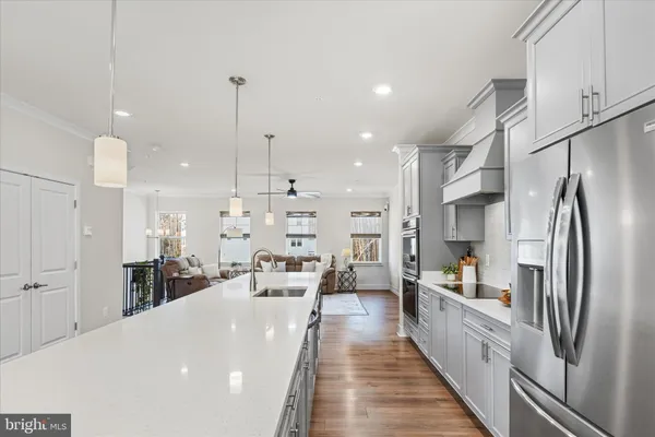 a large kitchen with kitchen island white cabinets and stainless steel appliances