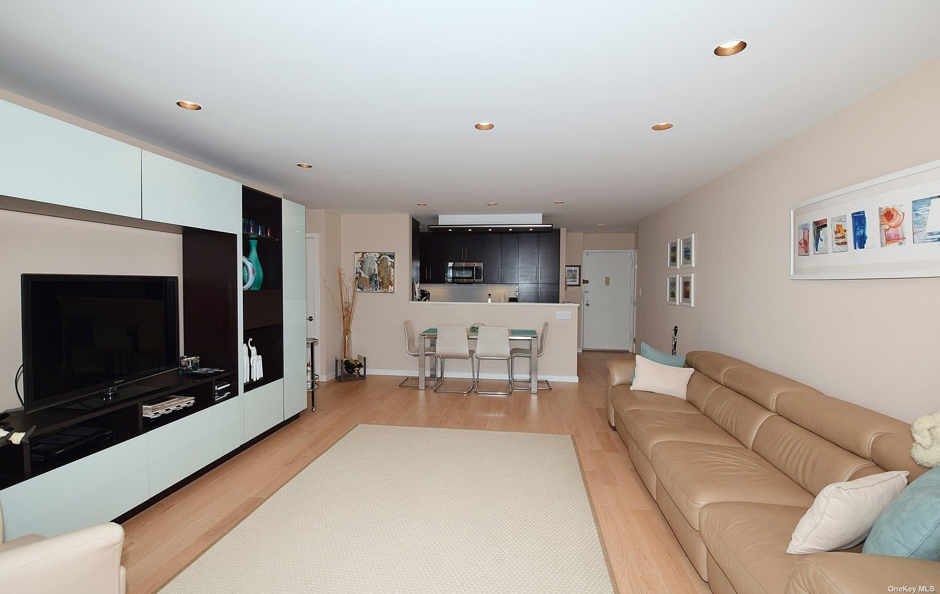 360 Shore Road, Unit 5E Long Beach, NY 11561 - Photo 11 of 21 a living room with furniture and a flat screen tv