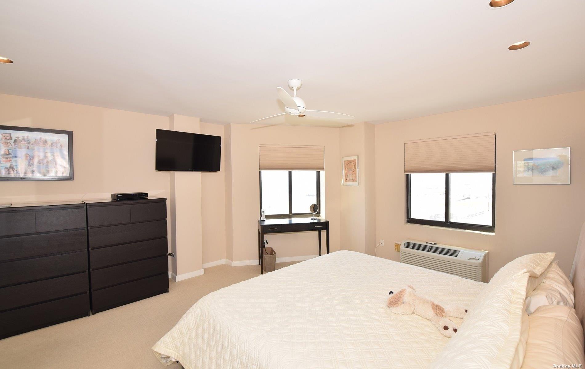 360 Shore Road, Unit 5E Long Beach, NY 11561 - Photo 14 of 21 a bedroom with a bed and a flat screen tv