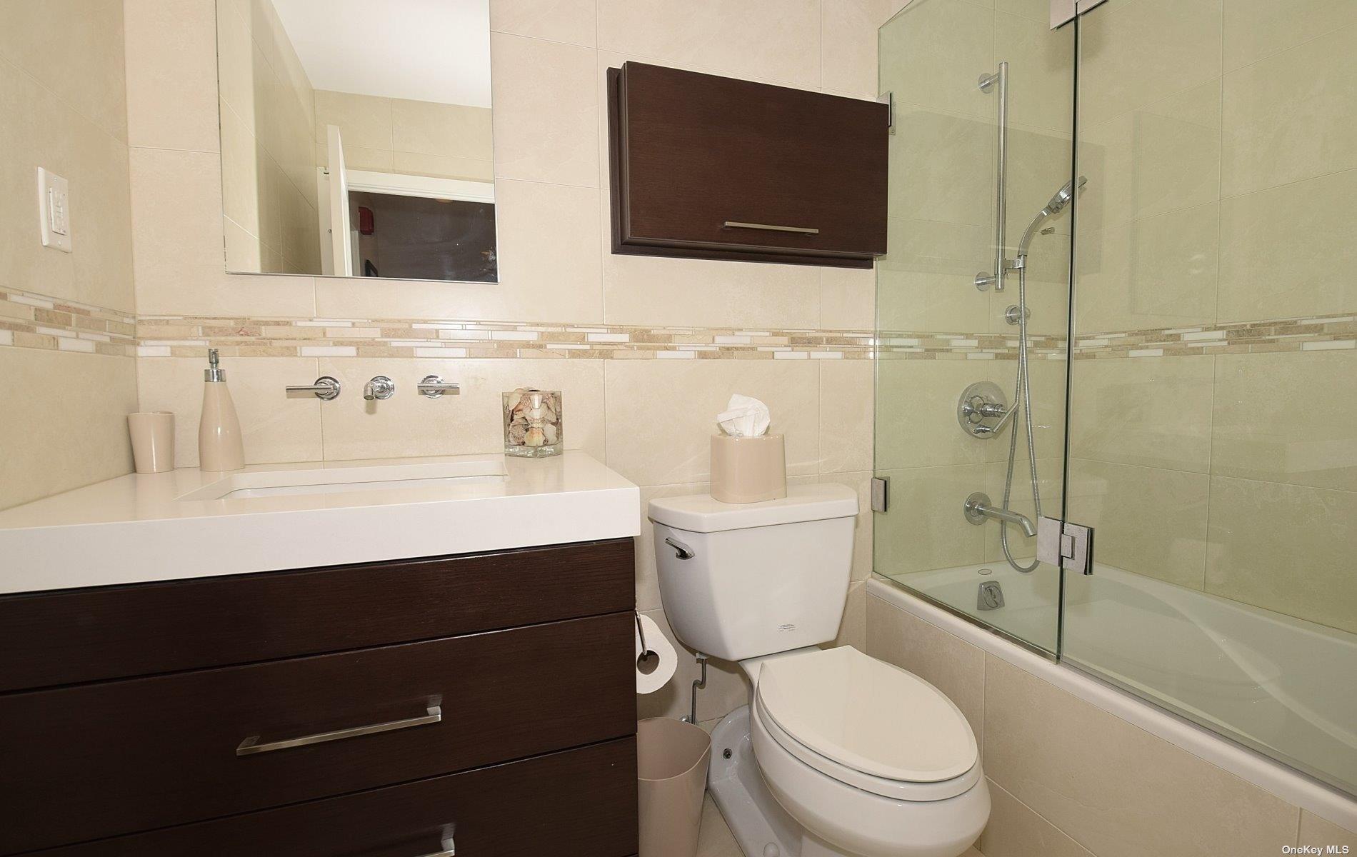 360 Shore Road, Unit 5E Long Beach, NY 11561 - Photo 17 of 21 a bathroom with a sink toilet a mirror and shower