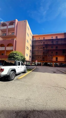 a view of building with cars parked