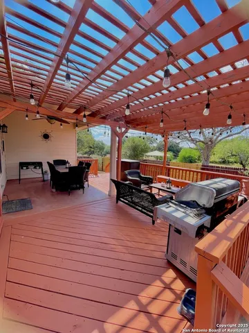 a view of a patio with table and chairs with wooden floor and fence