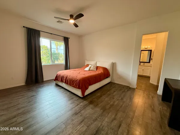 a bedroom with a bed and wooden floor