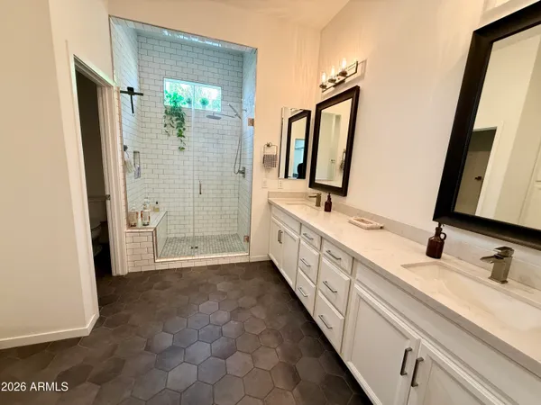 a bathroom with a double vanity sink a mirror and shower