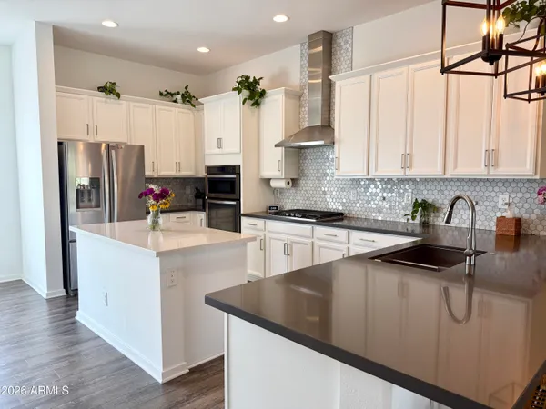 a kitchen with stainless steel appliances granite countertop a sink a stove and a refrigerator