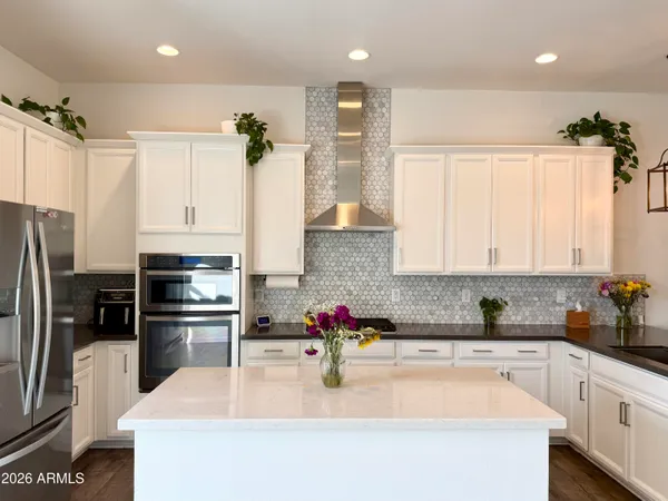 a kitchen with stainless steel appliances granite countertop a refrigerator sink and white cabinets