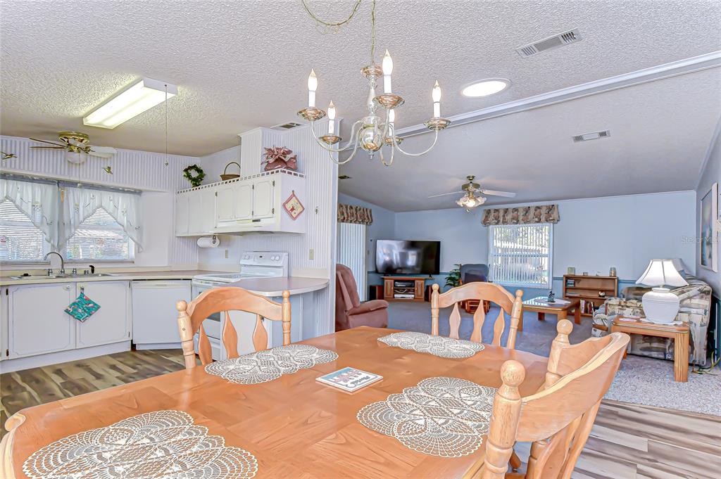 3210 Moonlight Street Wesley Chapel, FL 33543 - Photo 29 of 49 a living room with furniture a dining table and a chandelier