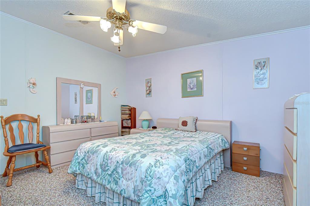 3210 Moonlight Street Wesley Chapel, FL 33543 - Photo 36 of 49 a bedroom with a bed and a chandelier