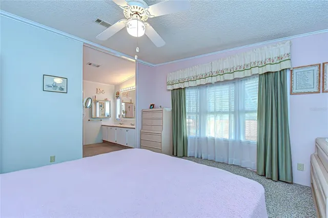 a spacious bedroom with a bed and a chandelier