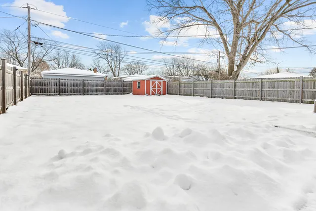 a view of white house with a snow in front of yard