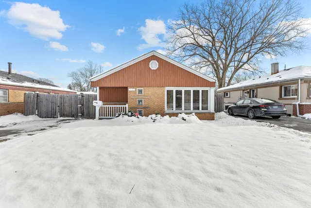 a view of a house with a yard covered in snow