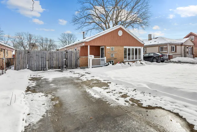 a front view of a house with a yard covered in snow