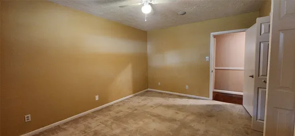 an empty room with a window and a fan