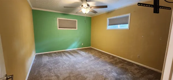 an empty room with a ceiling fan and a window