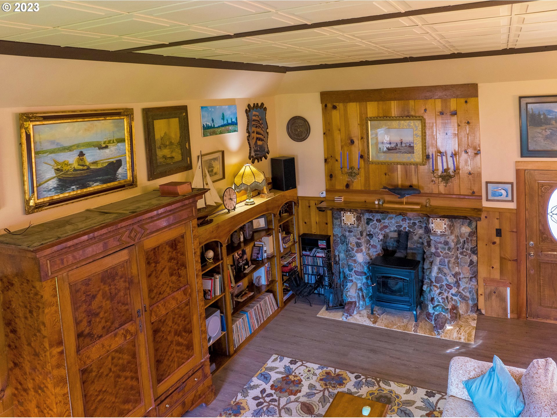 174 North 20th Street Reedsport, OR 97467 - Photo 14 of 43 a living room with furniture a fireplace and paintings on the wall