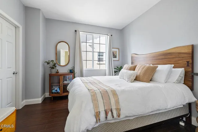 a bedroom with a bed a mirror and a window