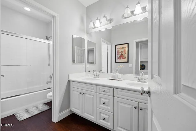 a bathroom with a double vanity sink a mirror and a shower