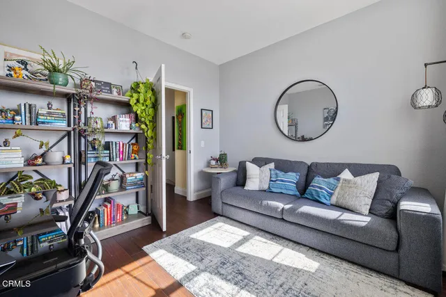 a living room with furniture a flat screen tv and a floor to ceiling window
