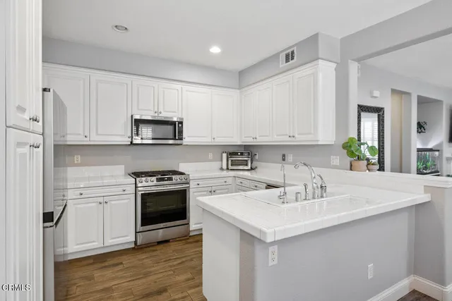 a kitchen with white cabinets and stainless steel appliances