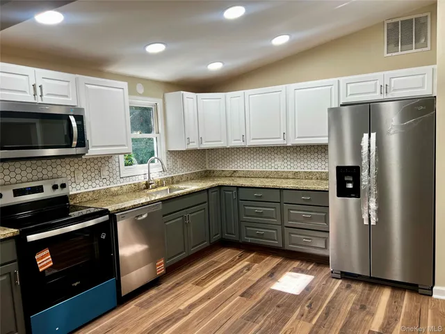a kitchen with wooden floors and appliances