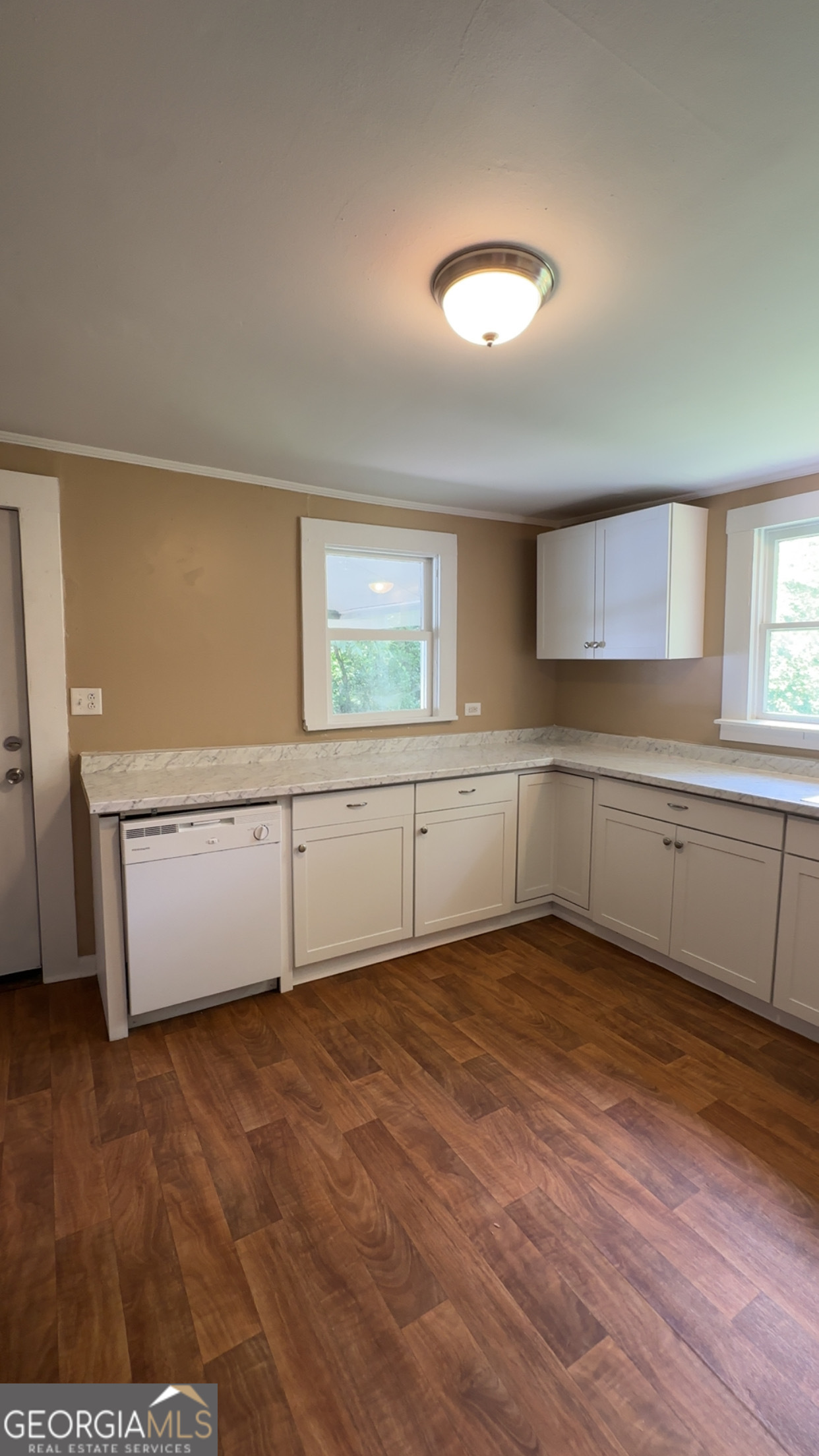 122 Hopkins Street Waycross, GA 31501 - Photo 16 of 31 a view of a kitchen with wooden floor and electronic appliances