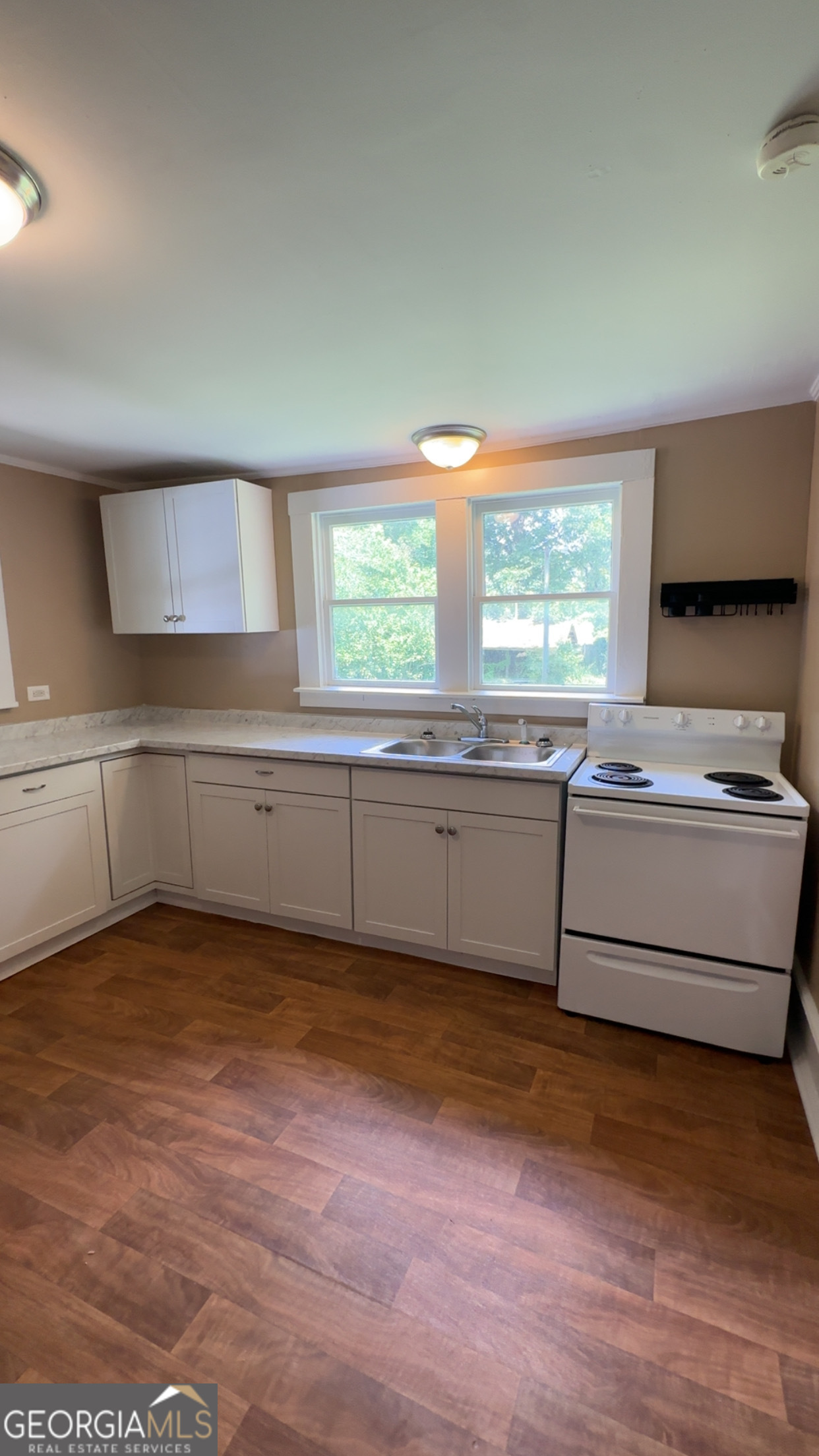 122 Hopkins Street Waycross, GA 31501 - Photo 17 of 31 a view of a kitchen with a sink dishwasher and wooden cabinets