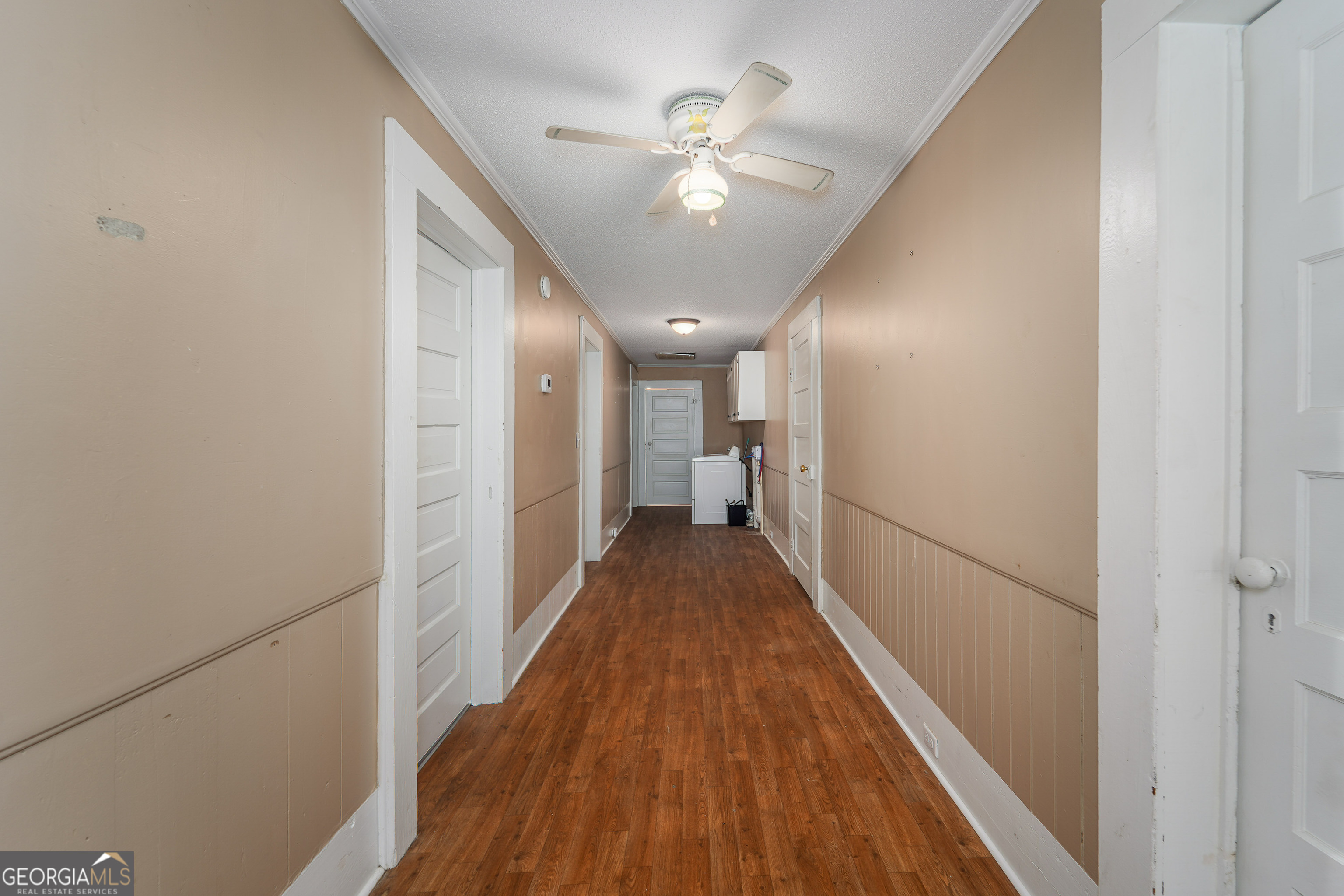 122 Hopkins Street Waycross, GA 31501 - Photo 20 of 31 a view of a hallway with wooden floor and a ceiling fan