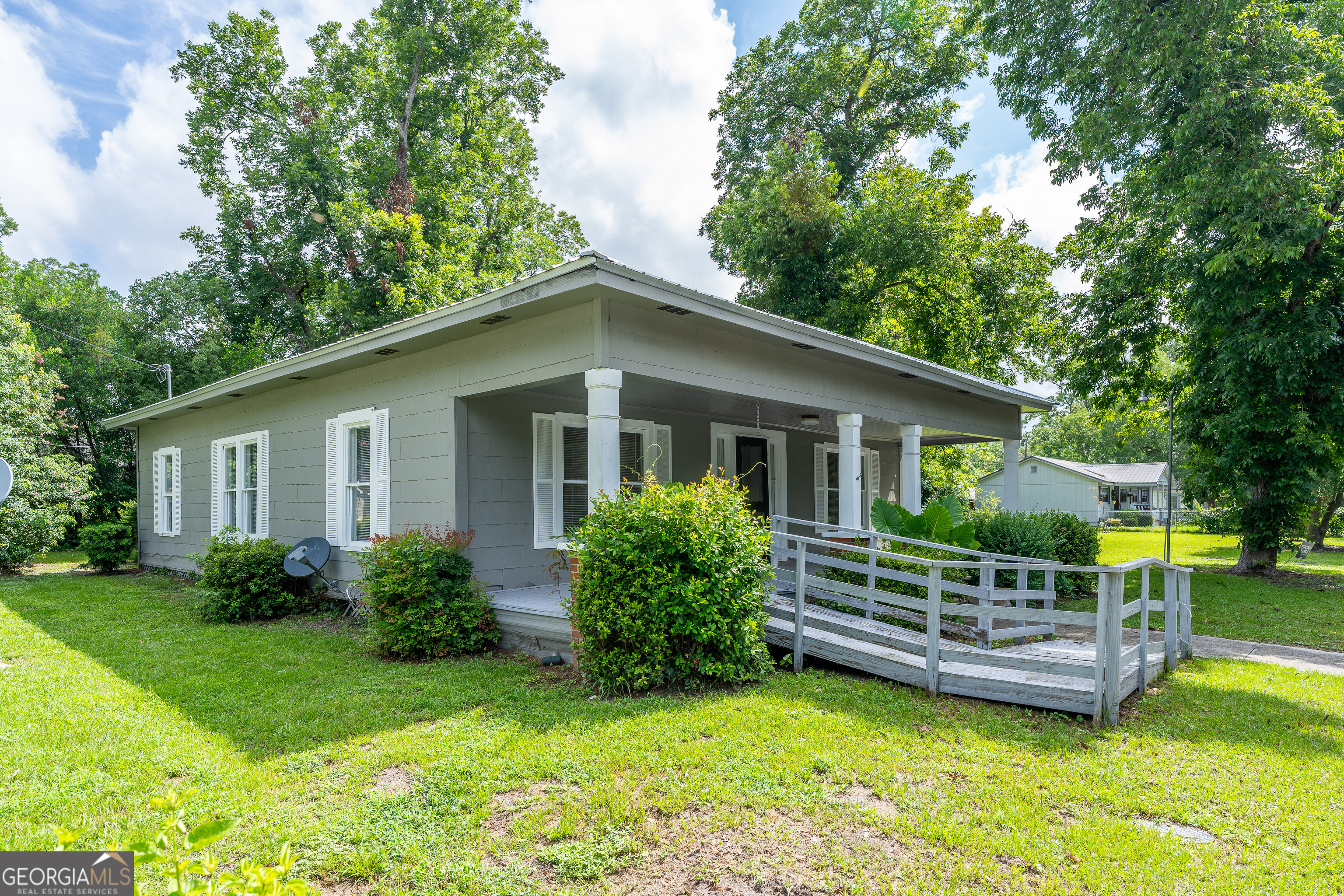 122 Hopkins Street Waycross, GA 31501 - Photo 7 of 31 a view of a house with a yard deck and a large tree