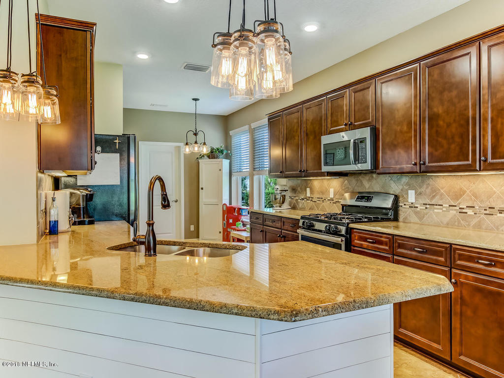 144 Maiden Terrace Ponte Vedra, FL 32081 - Photo 19 of 59 a kitchen with kitchen island granite countertop a sink stainless steel appliances and cabinets