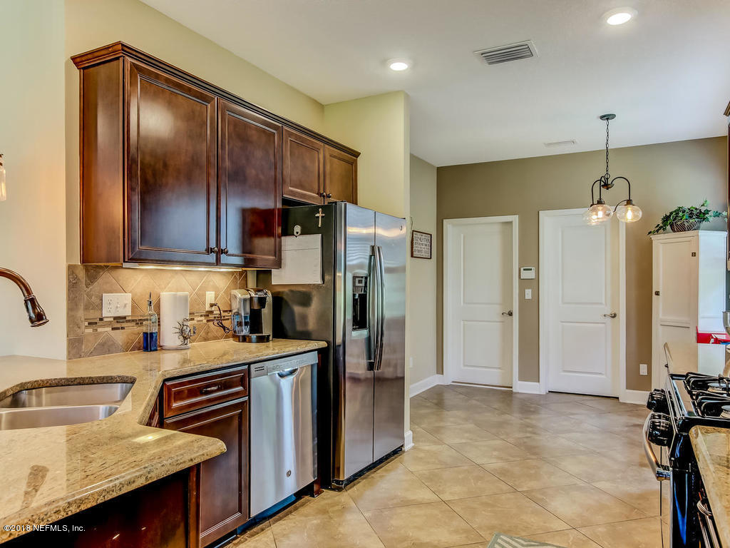 144 Maiden Terrace Ponte Vedra, FL 32081 - Photo 20 of 59 a kitchen with granite countertop a refrigerator a sink a stove and cabinets