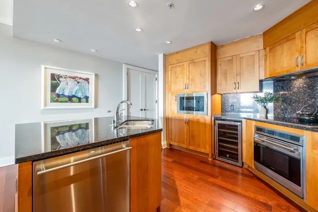 a kitchen with stainless steel appliances granite countertop a stove a sink and a microwave