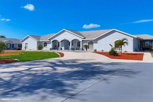 a view of a kitchen with kitchen island a stove a sink dishwasher and white cabinets with wooden floor