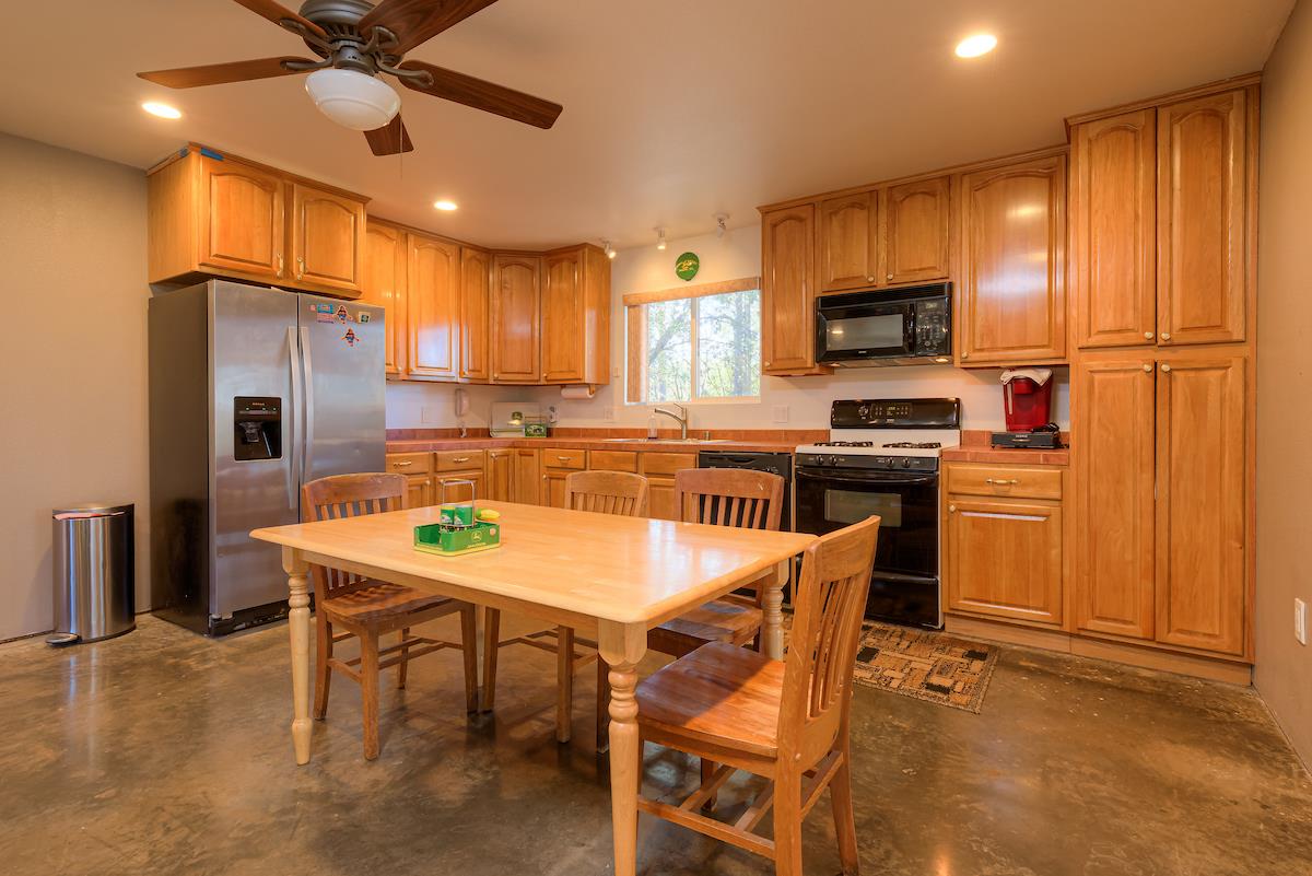 179 Elams Ranch Road Oroville, CA 95966 - Photo 8 of 52 a kitchen with a refrigerator a stove top oven a sink dishwasher and wooden cabinets