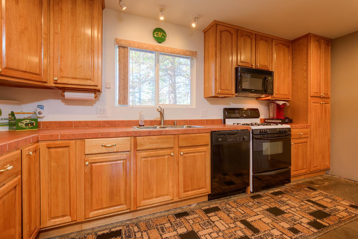 179 Elams Ranch Road Oroville, CA 95966 - Photo 10 of 52 a kitchen with stainless steel appliances granite countertop a stove a sink and a microwave