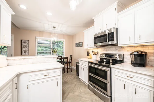 a kitchen with stainless steel appliances a stove microwave and sink