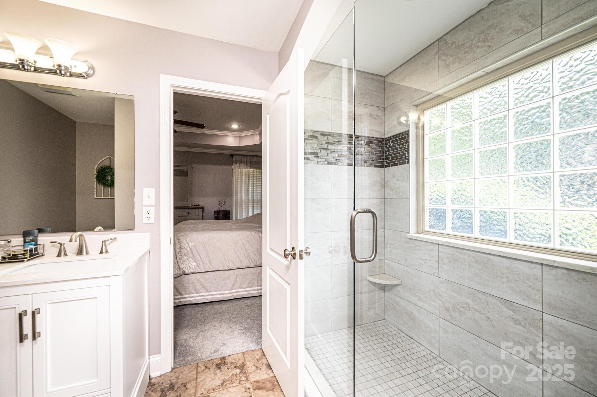 1784 New Star Drive Newton, NC 28658 - Photo 16 of 27 a bathroom with a granite countertop sink a mirror and a shower