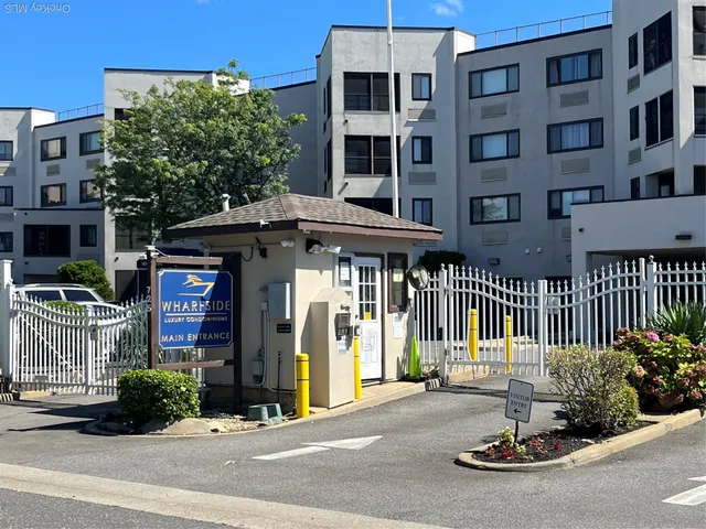 a front view of a building with a garden and plants